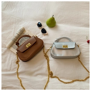 Chic chain crossbody bag detail with metallic lock and unique knotted handle design