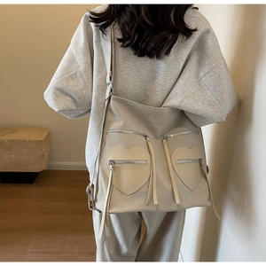 Detailed shot of beige corduroy backpack with heart-shaped pockets and silver zippers