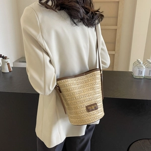 Summer woven straw bucket bag with brown leather trim and crossbody strap for women