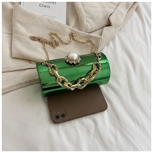 Top view of acrylic mirror cylinder bag with gold floral clasp and chain straps