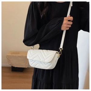 Detailed view of white V-quilted leather crossbody bag with gold metallic chain connectors