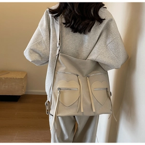 Detail of beige corduroy tote with two heart pockets and leather zipper pulls