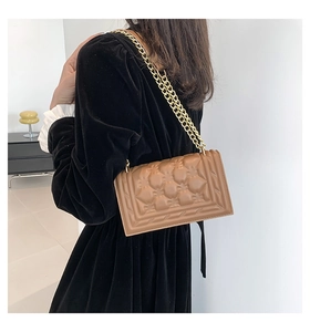 Detailed view of a brown quilted leather shoulder bag with elegant gold chain strap