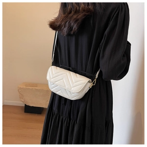 Minimalist white chevron quilted crossbody bag shown on a model with a black dress