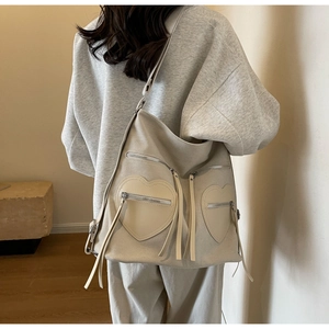 Detailed back view of model wearing a beige corduroy tote bag with heart-shaped pockets