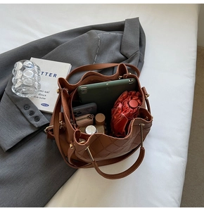 Detail view showing large capacity interior of brown quilted tote with gold handles