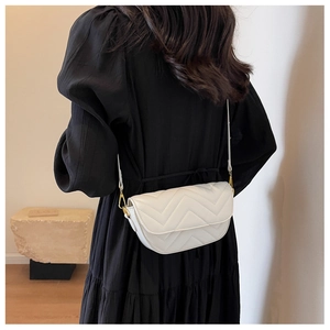 Modern white chevron quilted saddle bag shown on a model with black puff sleeve dress
