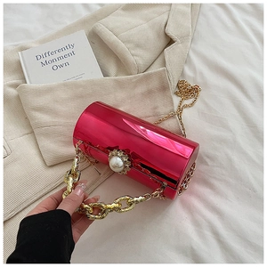 Macro detail of magenta metallic cylindrical clutch with pearl and rhinestone buckle