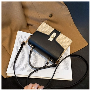 Detailansicht der beigen Stroh- und schwarzen Ledertasche mit goldener Metallschnalle