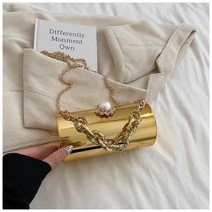 Detail of gold mirror cylinder evening bag with pearl clasp and chunky chain strap