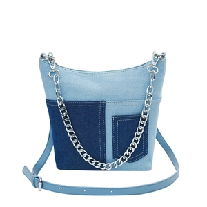 Chic patchwork denim bucket bag with silver chain strap and blue leather crossbody handle