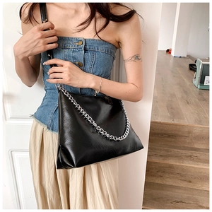 Detail of black faux leather tote with chunky silver chain and adjustable shoulder strap