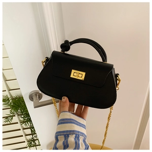 Detail of black leather handbag with golden twist lock and knot handle texture