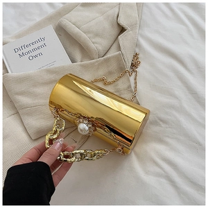 Detail of gold mirror cylinder bag with pearl rhinestone clasp and chunky chain strap