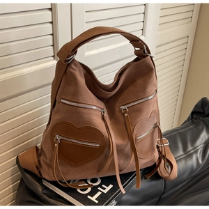 Detail of coffee brown corduroy tote bag with heart-shaped zipper pockets and leather puller