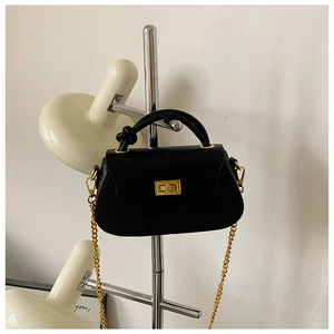 Detailed close-up of a black leather handbag featuring a golden twist lock and chain strap