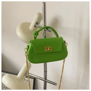 Detail view of fruit green crossbody bag with knot handle and golden twist lock closure