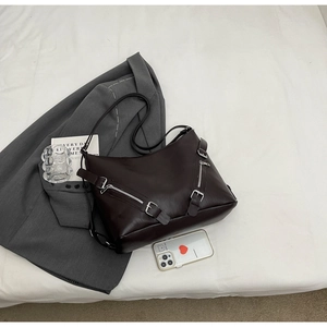 Flat lay of a vintage brown PU leather crossbody bag with dual front zipper pockets