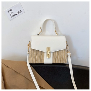 Nahaufnahme der Stroh-Klapptasche mit weißem Lederbesatz und elegantem goldenem Metallschloss