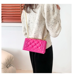 Detail of rose red quilted chain bag showing high-quality texture and gold metal strap
