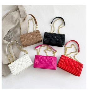 Flat lay of bubble quilted cross-body bags in five colors with golden chain straps