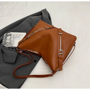 Detail view of brown PU leather tote with asymmetrical cut and silver metal zipper accents