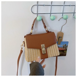 Detail der Damen-Strohhandtasche mit karamellbraunem Leder und goldener Schließe