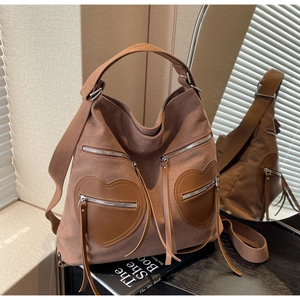 Close-up of brown corduroy tote bag featuring heart-shaped pockets and leather details