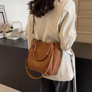 Brown leather bucket bag with quilted patterns and metal ring handles for women
