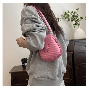 Detail view of pink crossbody bag with vertical striped embossing and flap closure