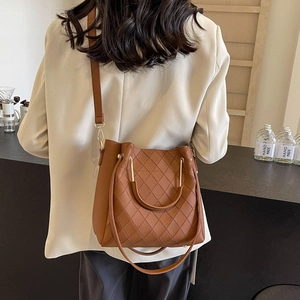 Brown quilted leather bucket bag with gold circular handle and adjustable shoulder strap