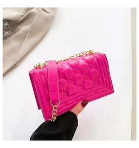 Detail view of the magenta quilted leather handbag with gold chain strap design