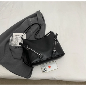 Detail of black faux leather tote with silver metal zippers and biker style hardware