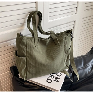 Close-up of army green corduroy tote bag featuring thick texture and side pocket detail