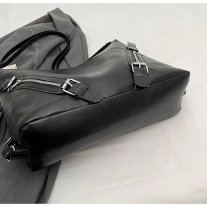 Close-up of black PU leather tote bag with silver zipper detail and lychee texture
