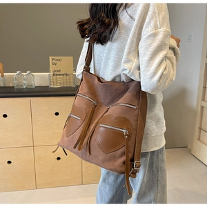 Detail of vintage corduroy brown backpack featuring two heart-shaped leather pockets