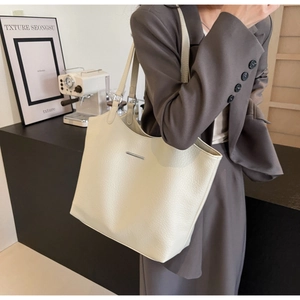 Detailed close-up of a large cream white tote bag featuring premium lychee pattern leather