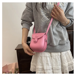 Detailed view of pink crossbody square bag with vertical texture and silver metal rings