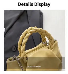 Detail of soft yellow pleated handbag showing thick braided leather handle and gold link