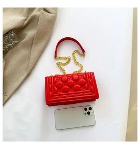 Detail of red quilted leather handbag with gold chain strap and smartphone for size