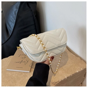 Detailed shot of chevron quilted cream white leather bag with gold chain strap