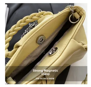 Detail view of the yellow pleated bag showing strong magnetic clasp and silver chain