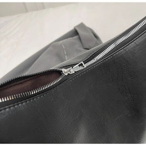 Detailed close-up of a black lychee texture tote bag featuring a silver metal zipper