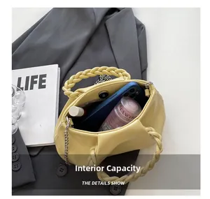 Internal capacity of yellow pleated cloud bag showing smartphone, lipstick and cosmetics