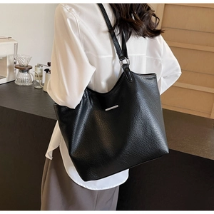 Lifestyle shot of large black lychee leather tote bag with silver detail on shoulder