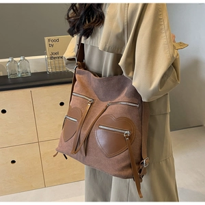 Detail shot of vintage brown corduroy backpack with heart-shaped pockets on a model