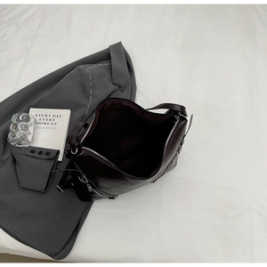 Top view of deep brown leather tote bag with side zipper details on white fabric