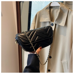 Detail of black quilted leather shoulder bag with V-shaped stitching and chain strap
