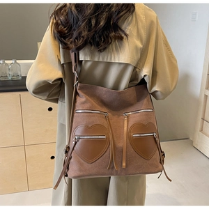 Detail of coffee brown corduroy backpack with heart leather pockets on khaki trench coat
