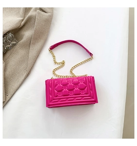 Detailed close-up of fuchsia quilted chain bag with elegant texture and golden metal strap